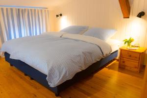 a bedroom with a bed with a blue and white comforter at Brise in Westermarkelsdorf