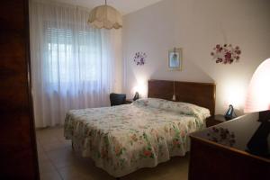 una camera da letto con un letto con copriletto floreale di APPARTAMENTI PANORAMICI VISTA MARE a Castiglione della Pescaia