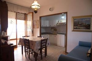 una cucina e una sala da pranzo con tavolo e sedie di APPARTAMENTI PANORAMICI VISTA MARE a Castiglione della Pescaia