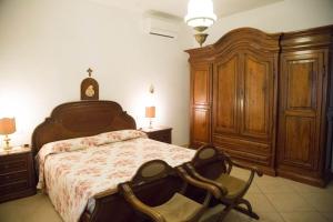 sypialnia z dużym łóżkiem i drewnianymi szafkami w obiekcie APPARTAMENTI PANORAMICI VISTA MARE w mieście Castiglione della Pescaia
