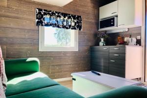 a living room with a green couch and a window at Alanko Lodge in Tornio