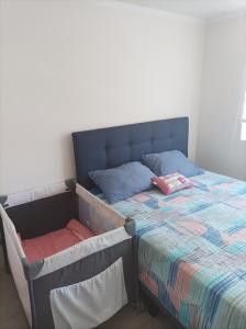 Bett mit blauem Kopfteil und Kissen darauf in der Unterkunft Vista Pacifico, Serena in La Serena