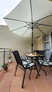 a patio with a table and chairs with an umbrella at I 6 Goose Valley! Golf and more in Plettenberg Bay