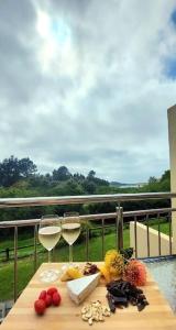 a table with two glasses of white wine on a balcony at I 6 Goose Valley! Golf and more in Plettenberg Bay +33 photos