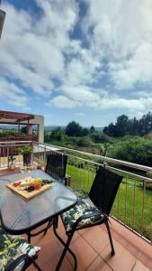 a table and two chairs on a balcony with a view at I 6 Goose Valley! Golf and more in Plettenberg Bay