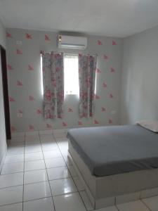 a bedroom with a bed with red flowers on the wall at Casa Beira Mar Serrambi in Porto De Galinhas
