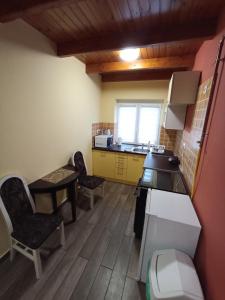 a kitchen with two chairs and a table in a room at Borostyán Apartmanház in Mórahalom