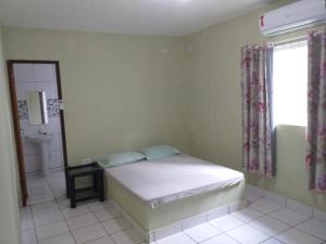 a bedroom with a bed and a bathroom with a window at Casa Beira Mar Serrambi in Porto De Galinhas