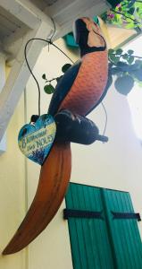 eine Statue eines Papageis, der an einer Wand hängt in der Unterkunft Maison PAPAGAYO in Oyster Pond