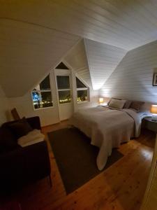 a bedroom with a large white bed and a couch at Cozy little house in Tromsø city in Tromsø