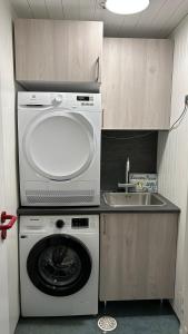 a kitchen with a washing machine and a sink at Cozy little house in Tromsø city in Tromsø