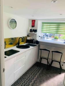 a kitchen with a sink and two chairs in it at The Pigsty in Braunton in Braunton