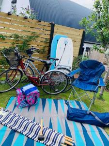 a picnic table with a surfboard and two chairs and a bike at The Pigsty in Braunton in Braunton