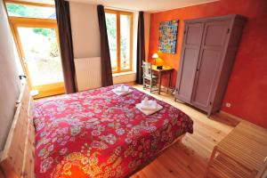 a bedroom with a red bed with two towels on it at Yak Avenir in Aiguilles