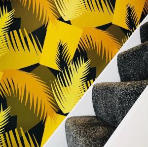 a wall with a yellow and black palm leaves wallpaper at The Pigsty in Braunton in Braunton