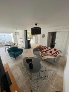 a living room with a couch and a table at Charmante maison au coeur du village de Saint-Trojan-les-Bains in Saint-Trojan-les-Bains