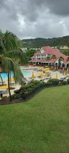 a resort with a pool with chairs and umbrellas at Olivera Studio P&V Ste luce in Sainte-Luce