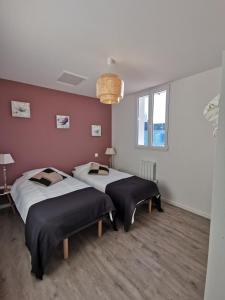 a room with two beds in a room at Charmante maison au coeur du village de Saint-Trojan-les-Bains in Saint-Trojan-les-Bains