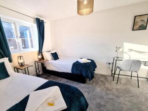 a hotel room with two beds and a chair at Stylish 3 Bedrooms & 2 Bathrooms House, Free Parking! in Cambridge