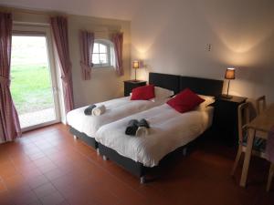 a bedroom with a large bed with red pillows at B&B De Pepper in Haaksbergen