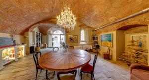 a dining room with a wooden table and a chandelier at Sestosenso Suites in Campiglia Marittima