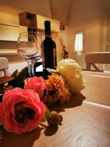 een fles wijn en bloemen op een tafel bij LA VECCHIA TORRE 1920 in Grottaglie