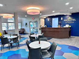 a restaurant with tables and chairs and a lobby at Microtel Inn & Suites by Wyndham of Houma in Houma