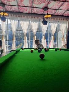 a little boy sitting at a pool table at The Bunker House in Chopta
