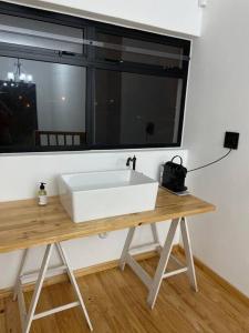 斯瓦科普蒙德的住宿－Swakopmund private room in family home，窗户前的木桌上的一个白色水槽