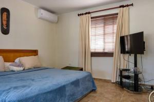 a bedroom with a bed and a flat screen tv at Private Peaceful Paradise on One Happy Island in Oranjestad