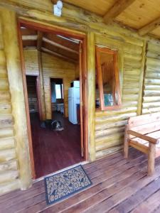 Cabaña de madera con banco en un porche en Cabaña La Isla II en 
