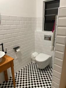 a bathroom with a white toilet and a black and white tile floor at Swakopmund private room in family home in Swakopmund