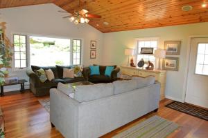 a living room with a couch and a ceiling fan at Carraig Mor Cottage - Beautiful House, Amazing Garden, Downtown Baileys Harbor in Baileys Harbor