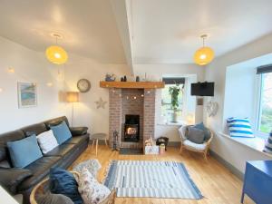 a living room with a couch and a fireplace at Laughing Seagull Cottage - unspoilt sea views in Castletownbere