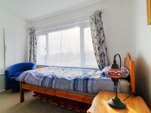 a small bedroom with a bed and a window at Owl Haven: Comfortable central 3 bedroom house, with an enclosed garden. in Bicester