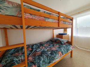 a bedroom with two bunk beds in a room at Owl Haven: Comfortable central 3 bedroom house, with an enclosed garden. in Bicester