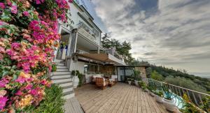 a house with a balcony with flowers on it at Sestosenso Suites in Campiglia Marittima