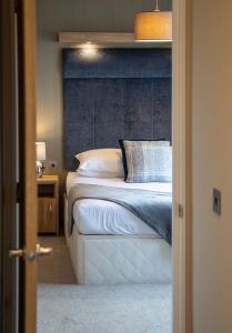 a bedroom with a bed with a blue headboard at Stewarts Resort Lodge 27 in St. Andrews