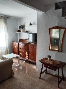 a living room with a wooden dresser and a mirror at La Casica in Chulilla +24 photos