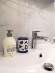 a bathroom sink with a bottle of soap next to a faucet at BNB Le BOHEMIEN Hyper Centre 5' Train Station in Orléans