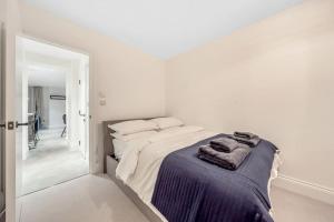 a white bedroom with a bed with towels on it at Trendy 2 bedroom 2 bathroom apartment minutes from seafront in St Leonard's Hastings in St. Leonards