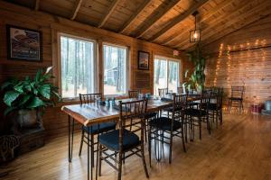 uma sala de jantar com uma mesa longa e cadeiras em The Lodge at Pleasant Point em Lovell