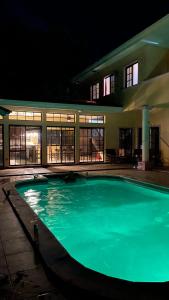 a swimming pool in front of a building at night at Casa Lila in Tela