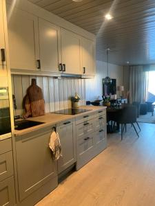 eine Küche mit weißen Schränken und ein Esszimmer in der Unterkunft Appartment Norefjell ski in/ski out in Noresund