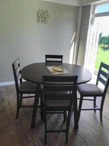 a dining room table with four chairs and a table and a table and chairsktop at 2 Bedroom Residential Rental Unit in Paix Bouche