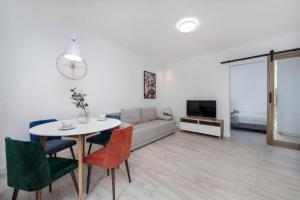 een woonkamer met een bank, een tafel en stoelen bij Apartament na Rybakach in Gdańsk