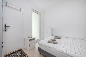 Habitación blanca con cama y ventana en Apartament na Rybakach, en Gdansk