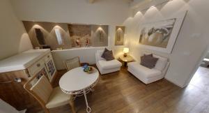 a living room with white furniture and a table and chairs at Sestosenso Suites in Campiglia Marittima +59 photos