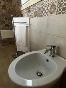 W łazience znajduje się biała umywalka i ręcznik. w obiekcie La Petraia w mieście Magliano