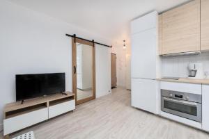 cocina blanca grande con TV de pantalla plana en Apartament na Rybakach, en Gdansk